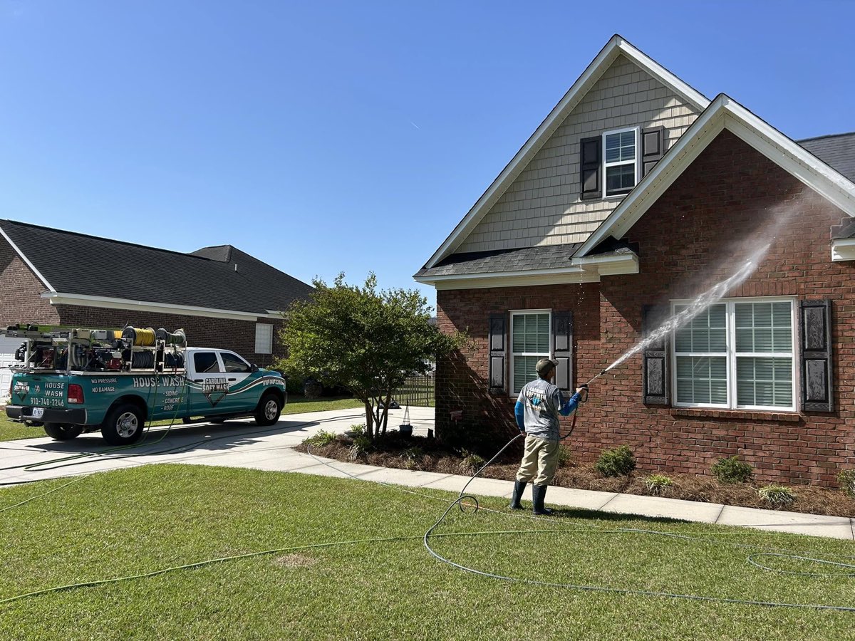 Carolina Soft Wash technician soft washing a brick home